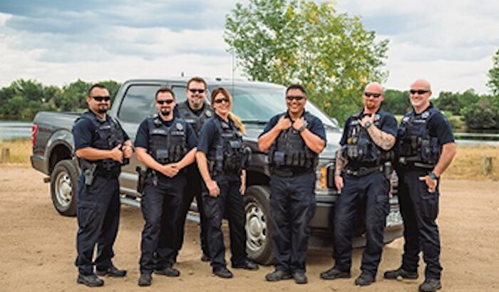 Adams County Sheriff Special Unit officers standing in front of a vehicle.