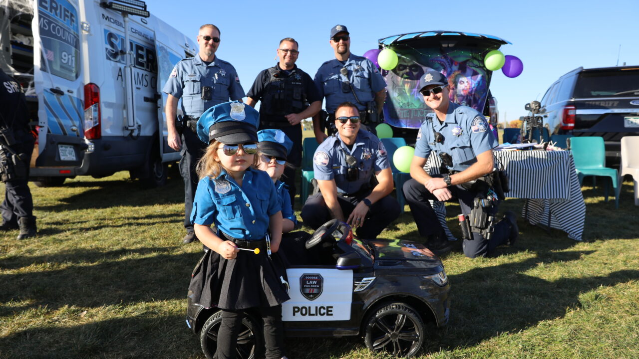 Children dressed as police officers standing with real officers at a community event