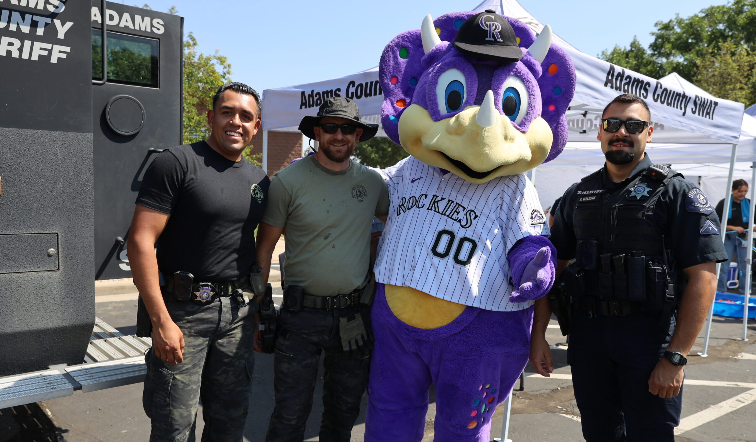 Dinger mascot with SWAT officers at Adams County event.