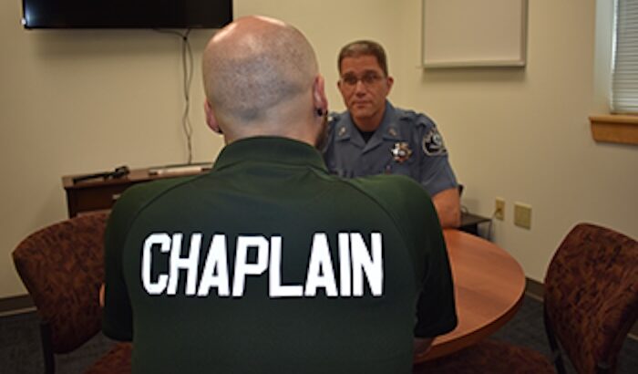 Chaplain talking with a uniformed officer at a small table