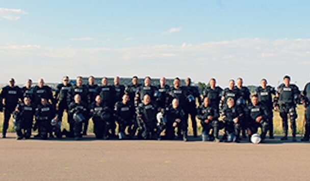 Mobile Field Force team of officers in tactical gear standing on a roadside